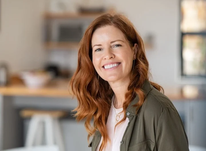 Smiling woman with perfect white teeth after cosmetic dental treatment, sitting in a modern Australian dental clinic.